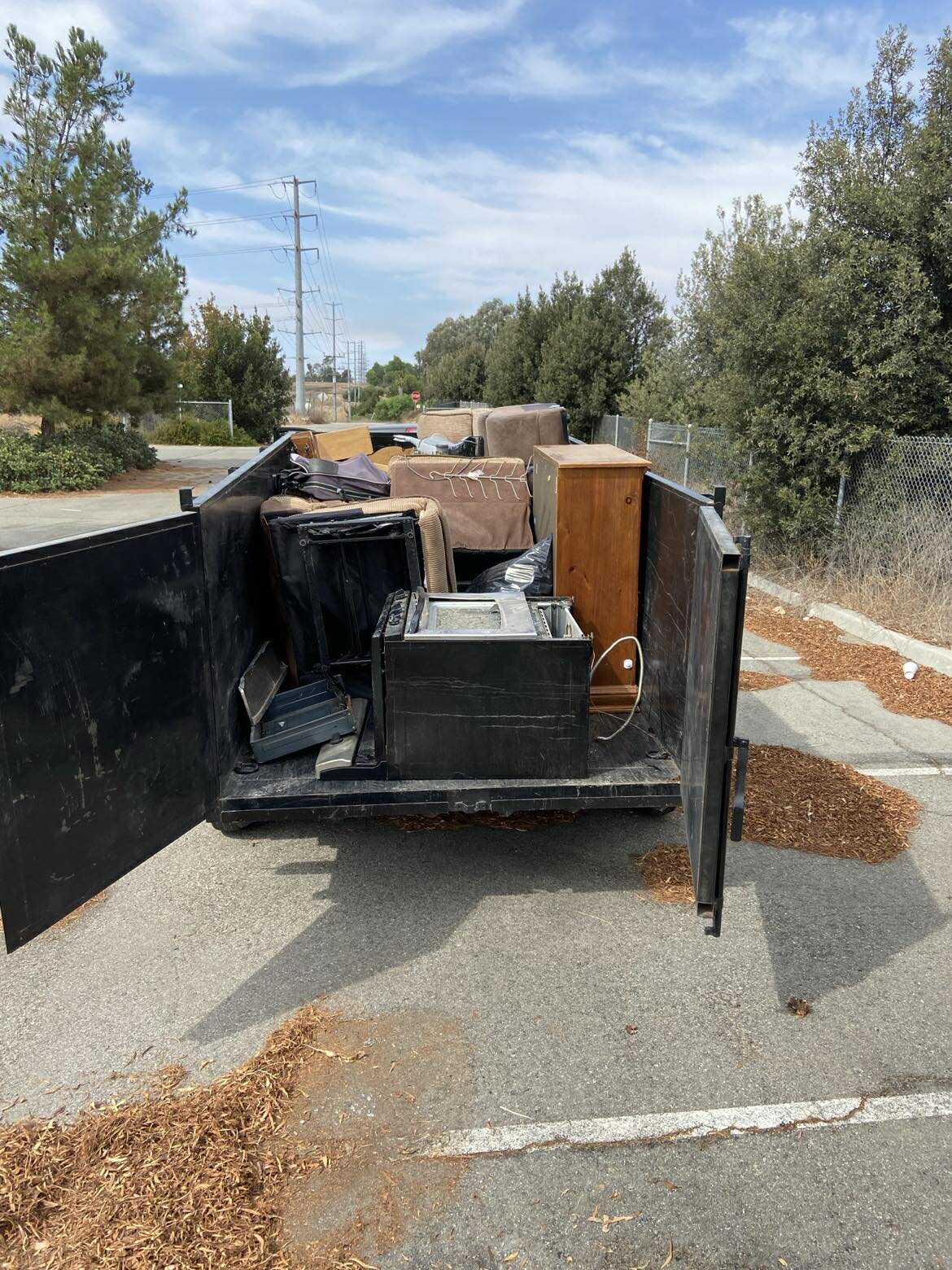 Dumpster rental filled with furniture and appliances in French Valley