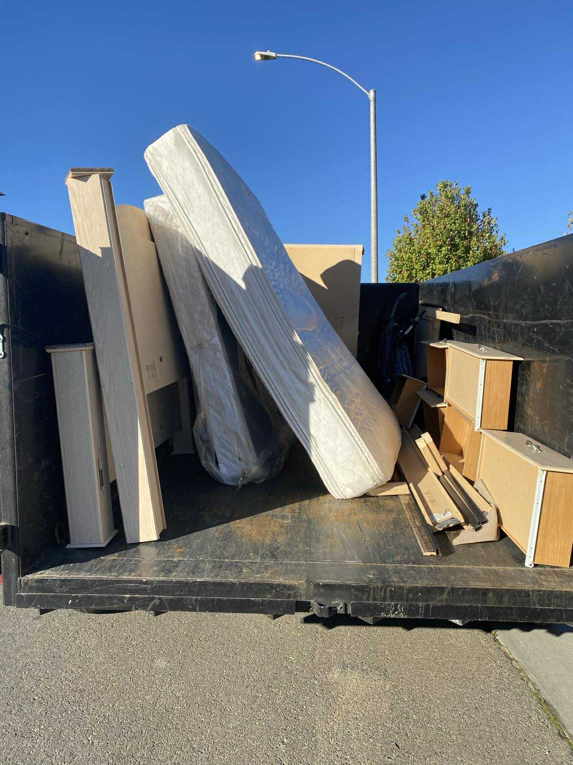 Junk removal truck loaded with mattresses and furniture in Temecula CA